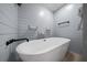 Elegant bathroom featuring a standalone tub, wood plank walls, and modern fixtures, creating a spa-like retreat at 9885 Se 144Th St, Summerfield, FL 34491