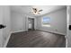 Bright bedroom with a window, ceiling fan, closet organizers, and wood floors, offering a comfortable space at 9885 Se 144Th St, Summerfield, FL 34491