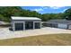 View of detached garage with multiple bays, attached carport, and side view of home at 9885 Se 144Th St, Summerfield, FL 34491