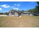 Charming gray home featuring a manicured lawn with fresh landscaping and a large garage at 9885 Se 144Th St, Summerfield, FL 34491