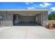 Spacious gray garage with a concrete driveway and visible electrical panel at 9885 Se 144Th St, Summerfield, FL 34491