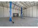 A garage interior with a car lift, work bench, and ample space, perfect for auto enthusiasts at 9885 Se 144Th St, Summerfield, FL 34491