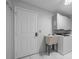 Bright laundry room featuring a utility sink, washer, dryer, and overhead cabinets for storage at 9885 Se 144Th St, Summerfield, FL 34491