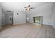 Open concept living room with light wood laminate flooring and sliding glass doors at 9885 Se 144Th St, Summerfield, FL 34491