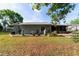 Backyard features a well-maintained lawn, mature trees, and covered patio with a screen at 1039 Ne 25Th St, Ocala, FL 34470