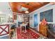 Dining room with rustic decor, wood ceiling, a red patterned rug, and decorative chalkboard at 1039 Ne 25Th St, Ocala, FL 34470