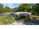 Single-story home featuring mature landscaping, an inviting carport, and a secure fenced-in yard at 1039 Ne 25Th St, Ocala, FL 34470