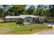 Charming single-story home with a well-maintained lawn, carport, mature trees, and a fenced yard at 1039 Ne 25Th St, Ocala, FL 34470