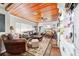 Cozy living room with wood ceiling, large leather sofa, and comfortable seating, creating a welcoming atmosphere at 1039 Ne 25Th St, Ocala, FL 34470