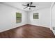 Well-lit bedroom with wood floors, a ceiling fan, and two windows at 10881 Sw 62Nd Avenue Rd, Ocala, FL 34476