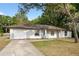 Attractive single-story home with a well-kept lawn, an attached garage, and mature trees at 10881 Sw 62Nd Avenue Rd, Ocala, FL 34476