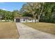Front exterior with mature trees and long driveway at 10881 Sw 62Nd Avenue Rd, Ocala, FL 34476