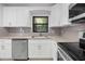 Updated kitchen featuring stainless steel appliances, granite countertops, and stylish white cabinets at 10881 Sw 62Nd Avenue Rd, Ocala, FL 34476