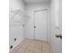 Small, tiled laundry room features a wire shelf above the hookups at 10881 Sw 62Nd Avenue Rd, Ocala, FL 34476
