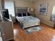 Comfortable bedroom featuring a mirrored bedframe, wood floors, and a silver dresser at 11120 Sw 71St Terrace Rd, Ocala, FL 34481
