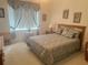 Bedroom with a queen bed, matching bedding, and lots of natural light from the window at 12453 Se 93Rd Court Rd, Summerfield, FL 34491