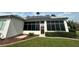 Exterior of sunroom with solar panels and well-maintained landscaping at 12453 Se 93Rd Court Rd, Summerfield, FL 34491