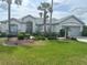 Charming single-story home with manicured lawn and mature landscaping, including palm trees at 12453 Se 93Rd Court Rd, Summerfield, FL 34491