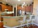 Kitchen featuring wooden cabinets, stainless steel appliances, and breakfast bar with three chairs at 12453 Se 93Rd Court Rd, Summerfield, FL 34491