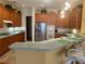 Kitchen with wooden cabinets, stainless steel appliances, and breakfast bar with seating at 12453 Se 93Rd Court Rd, Summerfield, FL 34491