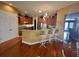 Kitchen with wooden cabinets, stainless steel appliances, breakfast bar with three chairs, and hardwood floors at 12453 Se 93Rd Court Rd, Summerfield, FL 34491