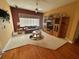 Comfortable living room with a sofa, entertainment center, and ceiling fan for relaxed living at 12453 Se 93Rd Court Rd, Summerfield, FL 34491