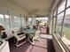 Enclosed sunroom with lots of natural light and comfortable seating area at 12453 Se 93Rd Court Rd, Summerfield, FL 34491