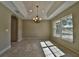 Dining room featuring tray ceilings, chandelier, tile floors, and bright window at 13099 Sw 78Th Ter, Ocala, FL 34473