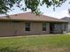Back exterior showing a screened lanai, windows and a manicured lawn for outdoor enjoyment at 13196 Se 86Th Cir, Summerfield, FL 34491