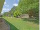 Lush backyard featuring a well-maintained lawn, mature trees, and a wooden fence for added privacy at 13196 Se 86Th Cir, Summerfield, FL 34491