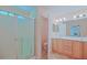 Bathroom with a glass door shower and double sink wooden vanity at 13196 Se 86Th Cir, Summerfield, FL 34491