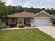 Charming single-story home featuring a two-car garage, manicured lawn, and well-maintained landscaping at 13196 Se 86Th Cir, Summerfield, FL 34491