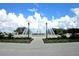 Beautiful outdoor fountain with manicured landscaping, lampposts, and a clear blue sky with puffy clouds at 13196 Se 86Th Cir, Summerfield, FL 34491