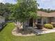 Charming front exterior featuring a well-manicured lawn and inviting entrance framed by mature landscaping at 13196 Se 86Th Cir, Summerfield, FL 34491