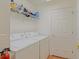 Functional laundry room with washer, dryer, storage shelf and easy access to other areas of the home at 13196 Se 86Th Cir, Summerfield, FL 34491