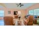 Spacious living room showcasing leather seating, a large TV, and views of the screened-in patio at 13196 Se 86Th Cir, Summerfield, FL 34491