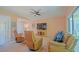 Open living room featuring comfortable leather seating, a large TV, and sliding glass doors to the patio at 13196 Se 86Th Cir, Summerfield, FL 34491
