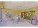 Charming screened patio with fan, seating, and sliding door entrance, perfect for relaxing and enjoying the outdoor view at 13196 Se 86Th Cir, Summerfield, FL 34491