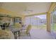 Relaxing screened patio featuring a ceiling fan, comfortable seating, and a view of the beautifully landscaped backyard at 13196 Se 86Th Cir, Summerfield, FL 34491