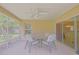 Inviting screened-in patio featuring a ceiling fan and outdoor seating, ideal for relaxing and enjoying the view at 13196 Se 86Th Cir, Summerfield, FL 34491