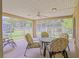 Enjoy the outdoors in this screened patio, complete with a ceiling fan and comfortable seating with a view of the backyard at 13196 Se 86Th Cir, Summerfield, FL 34491