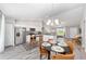 Bright kitchen features white cabinets, stainless steel appliances, and dining area with a modern chandelier at 13571 Sw 79Th Terrace Rd, Ocala, FL 34473
