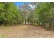 Lush backyard with trees offering privacy and a connection to nature, enhancing the property's appeal at 14620 Se 47Th Loop, Ocklawaha, FL 32179