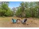 Outdoor seating area with two chairs, a fire pit, and surrounding trees, perfect for relaxing in nature at 14620 Se 47Th Loop, Ocklawaha, FL 32179