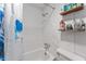 Close-up of a bathroom with a shower, toilet, and shelving for toiletries, accented by a floral shower curtain at 14620 Se 47Th Loop, Ocklawaha, FL 32179