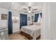 Comfortable bedroom with a ceiling fan, patterned bedding, and natural light from multiple windows with blue curtains at 14620 Se 47Th Loop, Ocklawaha, FL 32179