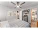 Bedroom with a ceiling fan, patterned bedding, white walls, and access to a private bathroom at 14620 Se 47Th Loop, Ocklawaha, FL 32179
