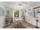 Bright dining area featuring a white table with seating, wood-look floors, and natural lighting at 14620 Se 47Th Loop, Ocklawaha, FL 32179