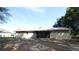 View of backyard, showcasing the house's exterior, a screened lanai, and a spacious open yard with mature trees at 16 Water Trak, Ocala, FL 34472