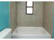 Tiled bathroom featuring a bathtub with shower and a small window at 16 Water Trak, Ocala, FL 34472